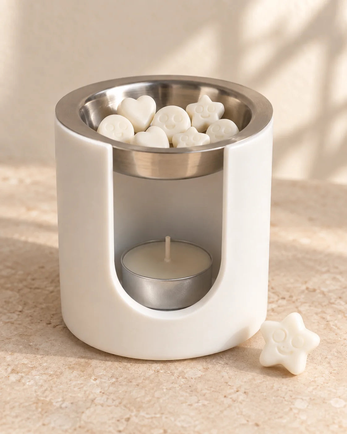Quemador de wax melts ZAEVA artesanal en resina mineral blanca con wax melts en el bol y una vela de té encendida debajo