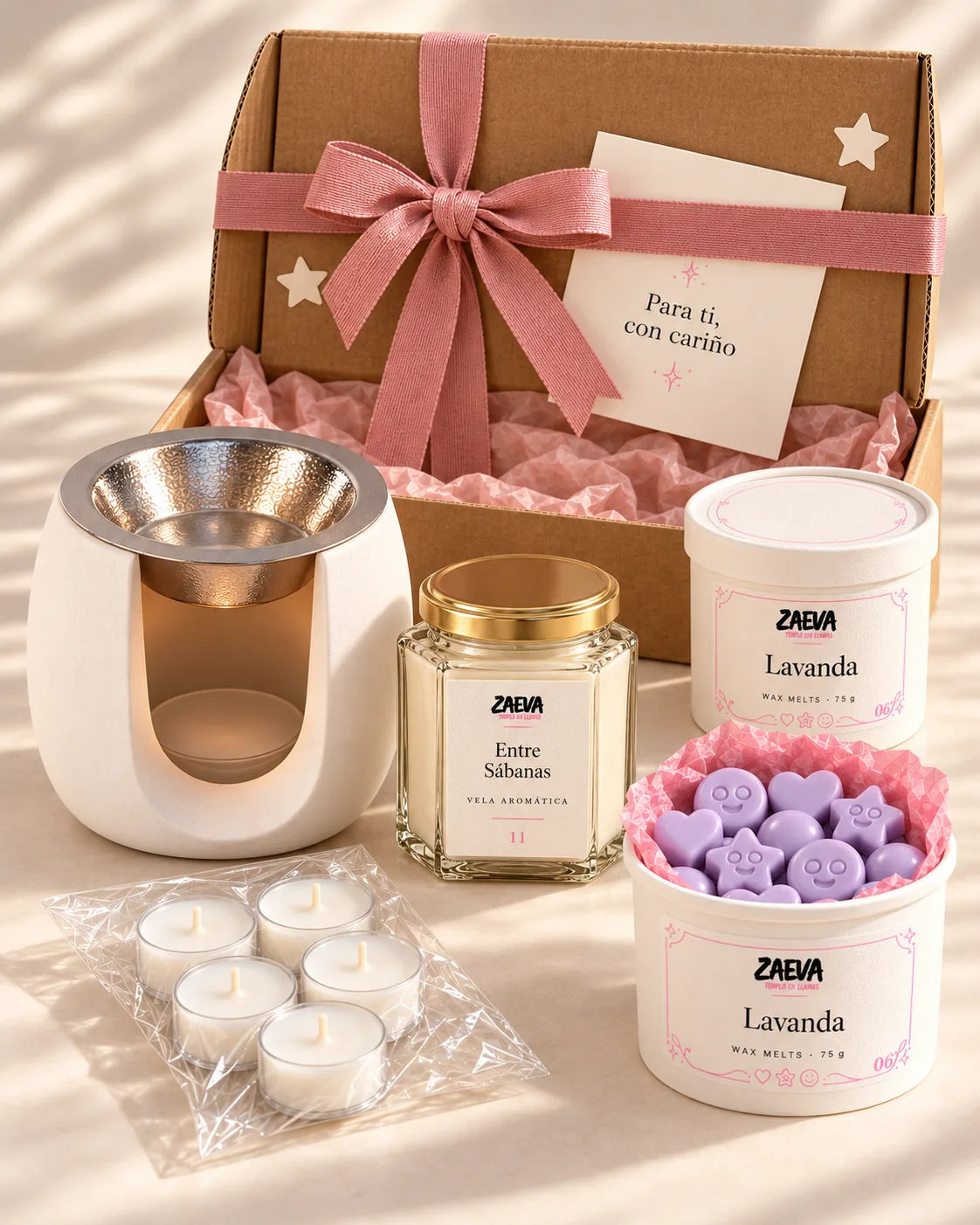 Pack de Navidad Hogar ZAEVA: quemador Onda, vela aromática de 200 g, dos tarrinas de wax melts y velas de té delante de su caja de regalo con lazo