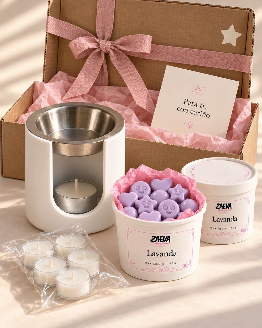Pack de Navidad Ritual ZAEVA: quemador Nido, dos tarrinas de wax melts de 75 g y velas de té delante de su caja de regalo con lazo