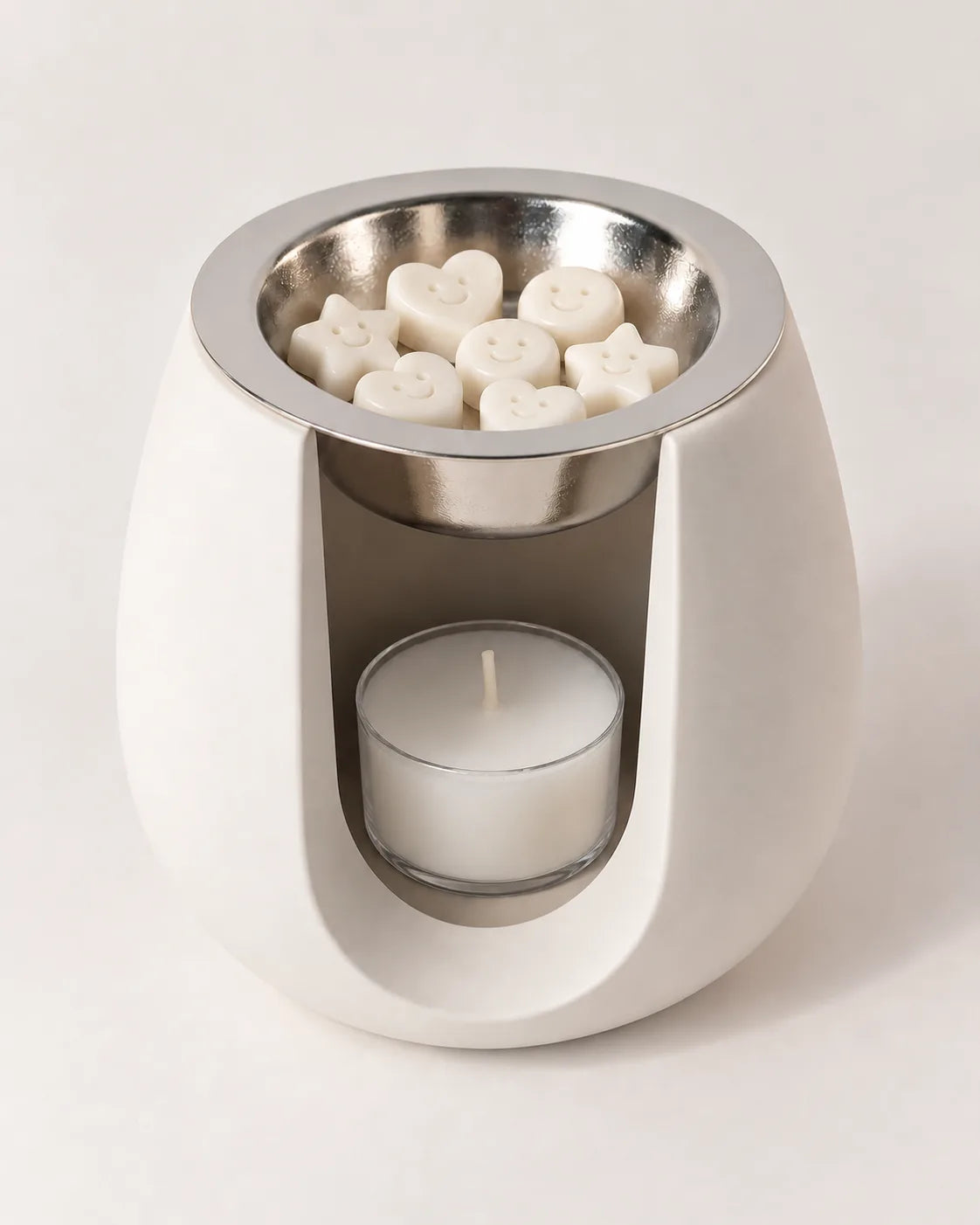 Quemador ZAEVA Onda con wax melts en el plato y vela de té encendida