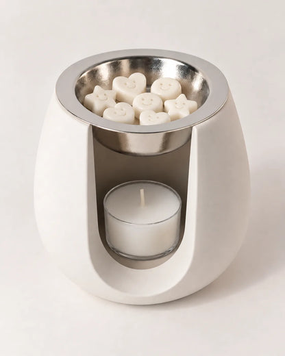 Quemador ZAEVA Onda con wax melts en el plato y vela de té encendida
